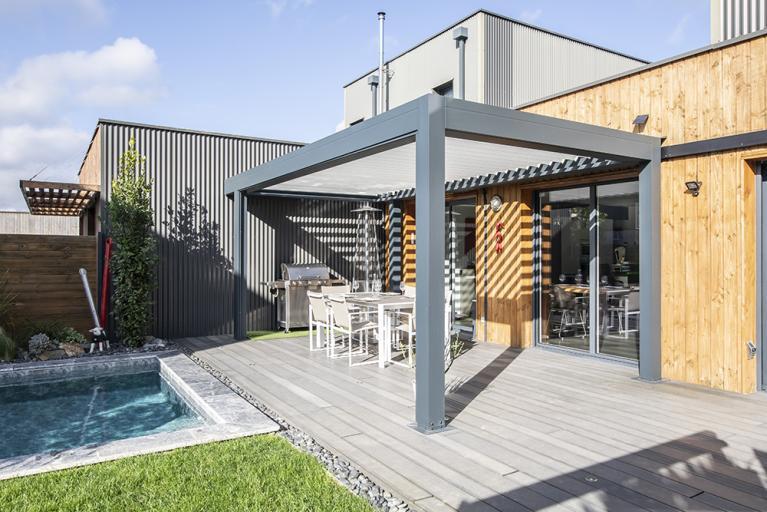 Installer une pergola blanche sur une terrasse en bois